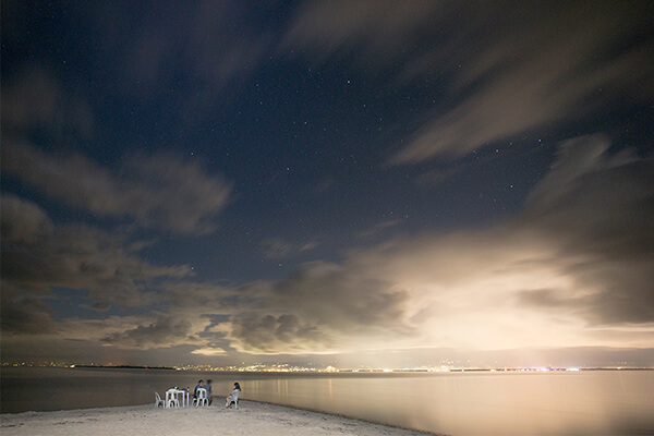 カオハガン島の夜のビーチで談笑する人々